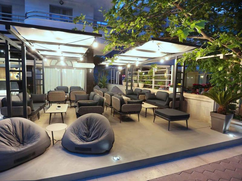 Modern outdoor area with cozy seating and lighting at dusk.