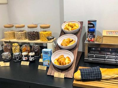 Un buffet per la colazione con cereali, pasticcini e marmellata in un hotel.