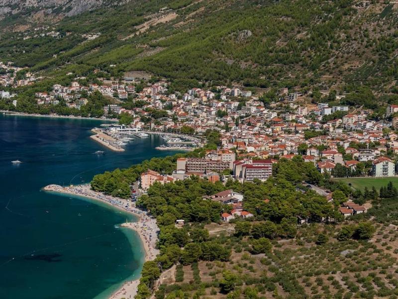 Veduta di una città costiera con spiagge, mare e montagne sullo sfondo