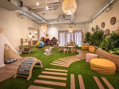 Children's playroom with wooden furniture, climbing equipment, and plant decor in warm lighting.