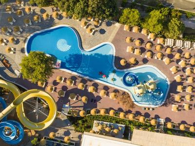 Aerial view of a water park with swimming pool, water slides, and sun umbrellas.