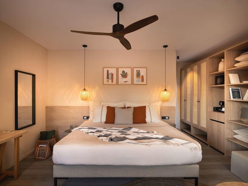 Cozy hotel room with large bed, bedside lamps, and open wardrobe.