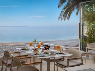 Terrasse mit gedecktem Frühstückstisch mit Meerblick unter blauem Himmel