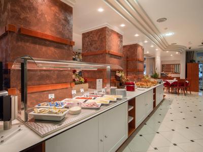 Comptoir de petit-déjeuner d'hôtel moderne avec éclairage chaleureux et variété de plats.