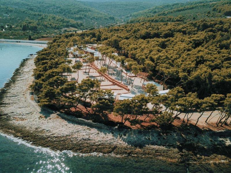 Coastal resort with tennis courts surrounded by trees and water