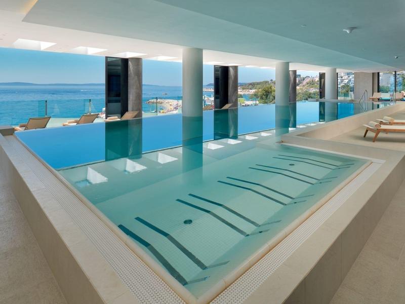 Nowoczesny basen kryty z panoramicznym widokiem na morze i wygodne leżaki.