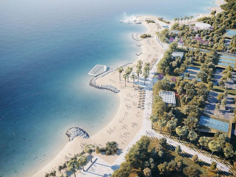 Widok z powietrza na ośrodek z piaszczystymi plażami, basenami i zielonymi terenami nad morzem.