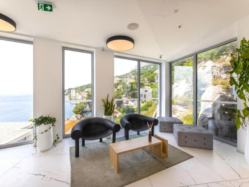 Helles Wohnzimmer mit großen Fenstern, Meerblick und modernem Mobiliar.