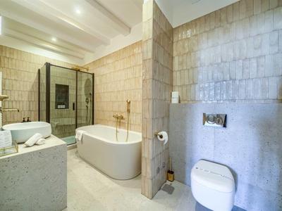 Modernes Badezimmer mit freistehender Badewanne, Dusche und weißem WC.