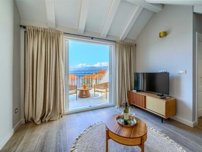 Helles Wohnzimmer mit Zugang zu einer Terrasse und Blick auf das Meer.