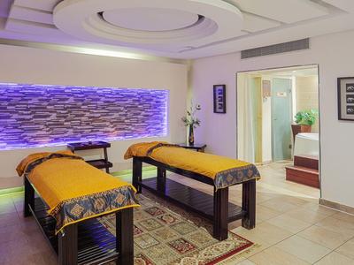 Modernes Spa mit zwei Massageliegen, weichen Teppichen und beruhigender Beleuchtung.