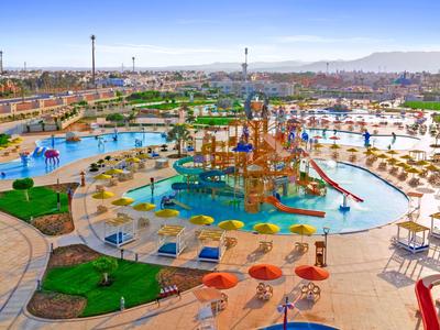 Großes Freizeitbad mit Wasserspielen, Rutschen und Liegestühlen unter sonnigem Himmel.