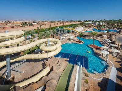Blick auf ein großes Hotel-Wasserpark mit Rutschen und Pool unter blauem Himmel.