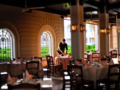 Elegantes Restaurantambiente mit gedeckten Tischen und Blick auf Fensterbögen.