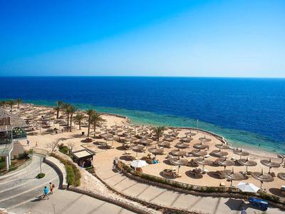 Spiaggia con ombrelloni e vista sul mare blu sotto un cielo sereno.