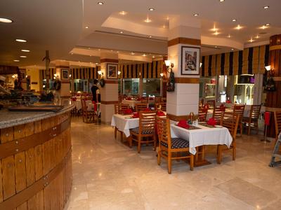 Restaurantinterieur mit gedeckten Tischen, Holzmöbeln und gedämpfter Beleuchtung.