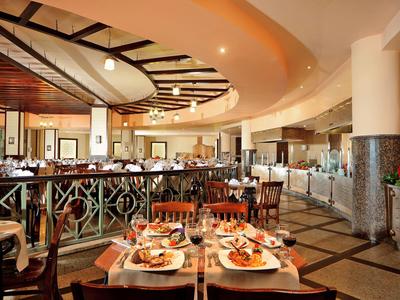 Elegantes Hotelrestaurant mit gedeckten Tischen und warmem, einladendem Ambiente.