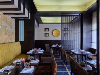 Elegantes Restaurantinterieur mit gelbem Sitz und dunklem Holzdekor.