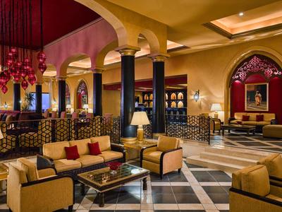 Elegante Hotel-Lobby mit bequemen Sitzbereichen, Säulen und warmem, gelbem Licht.