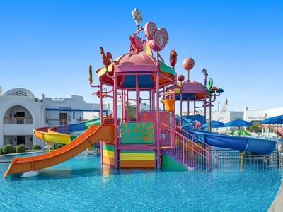 Buntes Wasserspiel mit Rutschen und Figuren in einem Hotelpool unter klarem Himmel.