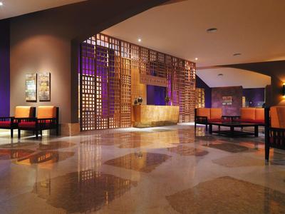 Moderne Hotellobby mit stilvollen Sitzbereichen, warmem Licht und eleganter Holzverkleidung.