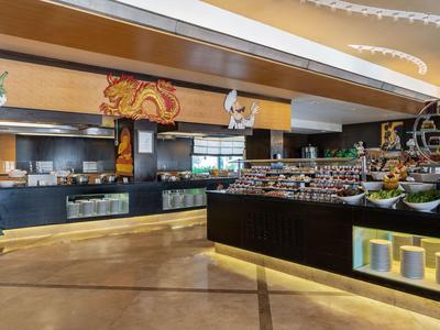 Moderner Hotel-Speisesaal mit Buffet und warmen Holzakzenten.