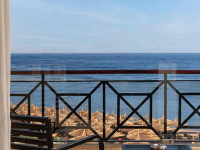 Balcone con sedia e tavolo, vista sul mare e cielo sereno sullo sfondo.