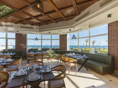 Modernes Hotelrestaurant mit Panoramablick auf das Meer und eleganter Einrichtung.