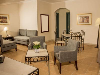 Moderne Hotellounge mit grauen Sitzmöbeln und einem kleinen Tisch mit Blumen.
