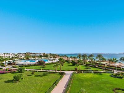 Ampia area dell'hotel con giardini curati, piscina e vista sul mare e sulle montagne.