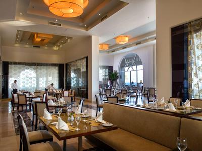 Elegantes Hotelrestaurant mit gedeckten Tischen, bequemen Stühlen und warmem Licht.