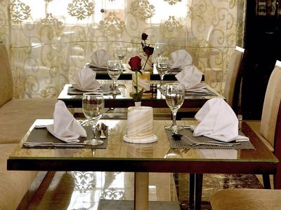 Eleganter Esstisch für vier Personen mit weißen Servietten und Weinflasche in stilvollem Restaurant.