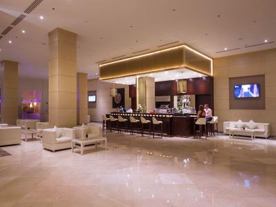 Eleganter Hotel-Lobbybereich mit Bar, bequemen Sesseln und gedämpfter Beleuchtung.