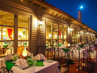 Abendliches Terrassenrestaurant mit gedeckten Tischen und warmem Licht in einem Hotel.