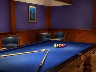 Ein Billardtisch mit blauem Tuch und mehreren Bällen in einem luxuriösen Spielzimmer.