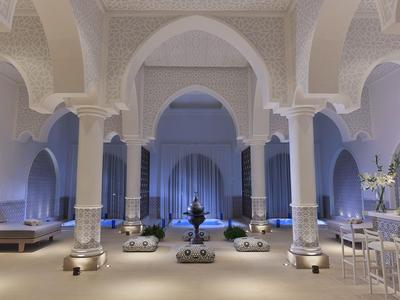 Eleganter Hotel-Lobbybereich mit hohen Bögen, Säulen und stilvoller Beleuchtung.