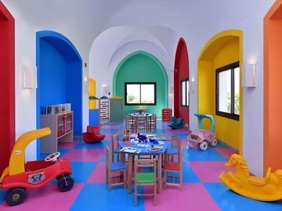 Bunt eingerichteter Kinderspielraum mit kleinen Möbeln und Spielzeug in einem Hotel.