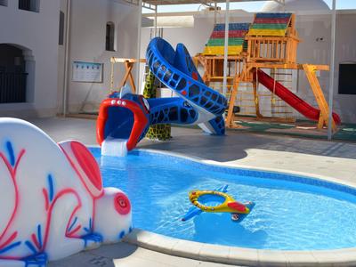 Kinderpool mit buntem Hasenrutsche und Spielturm mit Rutschen unter Überdachung.