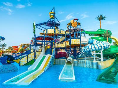Ein farbenfroher Wasserspielplatz mit mehreren Rutschen und Wasserfällen unter blauem Himmel.