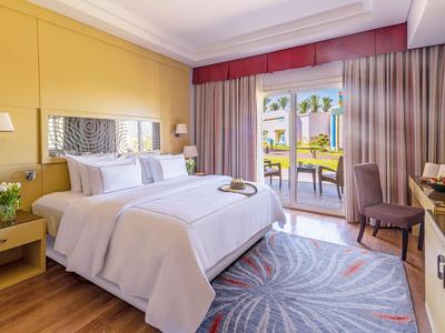Modernes Hotelzimmer mit Doppelbett, Balkon mit Meerblick und stilvoller Einrichtung.