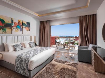Modern eingerichtetes Hotelzimmer mit Balkon und Meerblick an einem sonnigen Tag.