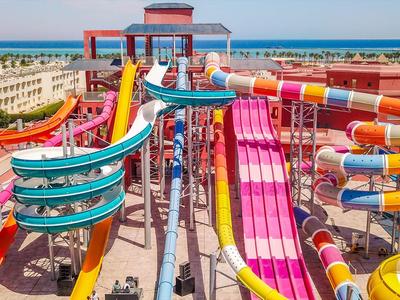 Bunte Wasserrutschen in einem Freizeitpark mit Blick auf den Strand und das Meer.