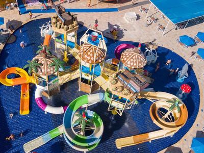 Bunter Wasserpark mit Rutschen und Sonnenschirmen neben einem Hotelpool