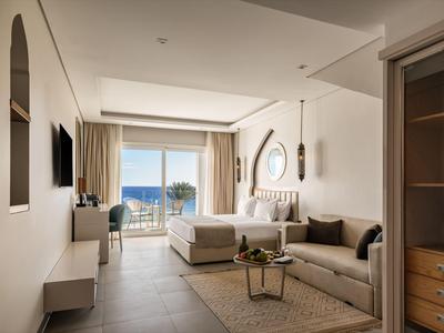 Salon moderne avec grande fenêtre et vue sur la mer dans un hôtel.
