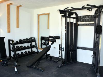 Moderner Fitnessraum mit Gewichten und Trainingsgeräten in einem Hotel.