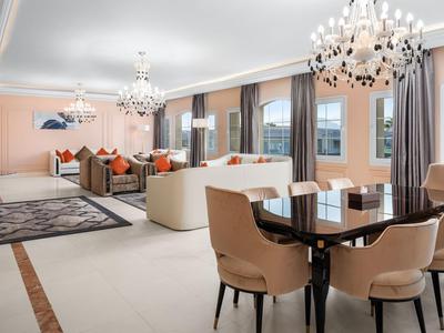 Helles Wohnzimmer mit beigem Sofa, Esstisch und großen Fenstern mit Aussicht.