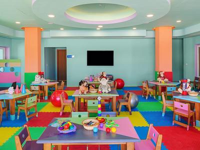 Bunter Kinderspielraum mit Spielzeugen, Tischen und Stühlen in einem Hotel.