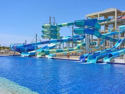 Großer Wasserpark mit mehreren bunten Wasserrutschen und klarem blauen Pool.