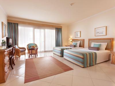 Moderner Speisesaal mit großen Fenstern, Holzboden und Deckenventilatoren in einem Hotel.
