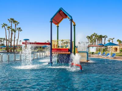 Wasserpark mit Wasserspielen und einem blauem Himmel im Hintergrund.